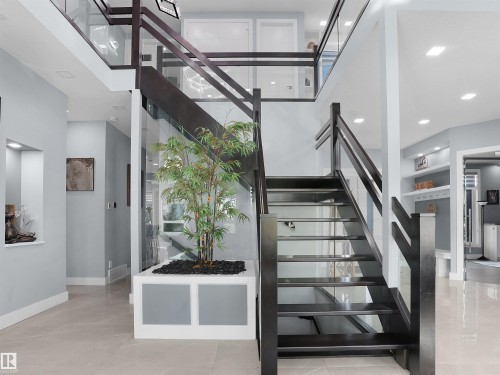 Grand two-story foyer featuring an open-tread staircase with dark wood and glass railings - 913 Wood Place, Edmonton, AB - Indoor Photo Showing Other Room