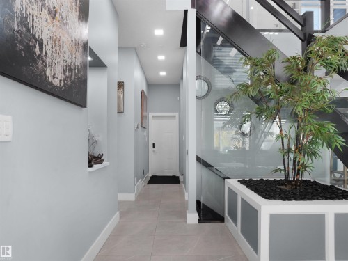 Hallway featuring recessed ceiling lighting, light-toned tile flooring, and white baseboards - 913 Wood Place, Edmonton, AB - Indoor