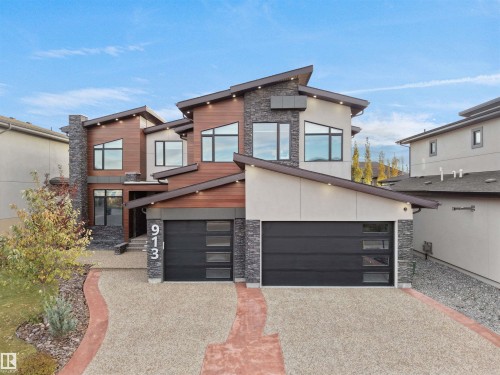 Modern architectural exterior featuring wood-tone siding, stacked stone accents, and varied rooflines - 913 Wood Place, Edmonton, AB - Outdoor