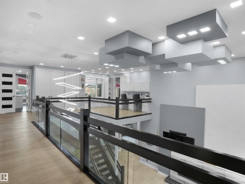 Open-concept upper level featuring glass panel railings, wood-finish flooring, and recessed lighting - 913 Wood Place, Edmonton, AB - Indoor Photo Showing Other Room