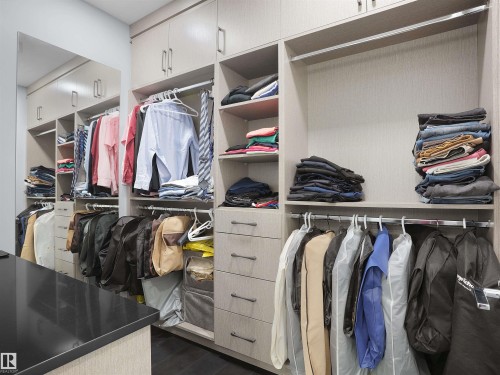 Custom closet system with light wood-finish cabinetry, ample shelving, multiple hanging rods, and integrated drawers - 913 Wood Place, Edmonton, AB - Indoor With Storage