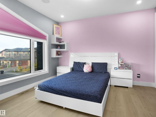 Bedroom featuring wood-finish flooring, recessed lighting, and a large multi-pane window - 913 Wood Place, Edmonton, AB - Indoor Photo Showing Bedroom