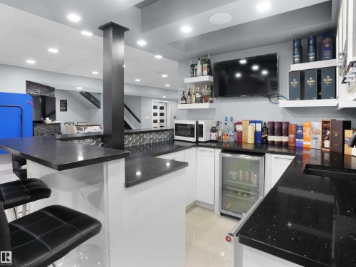 Custom bar area featuring solid surface countertops, white cabinetry, built-in beverage refrigerator, and recessed lighting - 913 Wood Place, Edmonton, AB - Indoor Photo Showing Kitchen