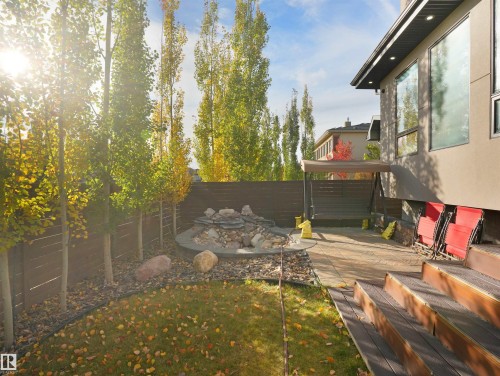 Expansive backyard with a manicured lawn, established trees, and a stone water feature - 913 Wood Place, Edmonton, AB - Outdoor With Deck Patio Veranda