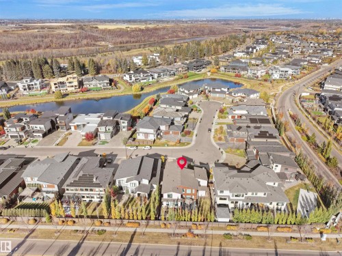 Aerial view of a residential community featuring a prominent body of water, extensive green spaces, and a variety of contemporary-style homes - 913 Wood Place, Edmonton, AB - Outdoor With View