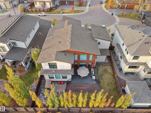 Rear exterior featuring a multi-level composite deck, a lower paver patio, and a fenced yard with established trees - 913 Wood Place, Edmonton, AB - Outdoor