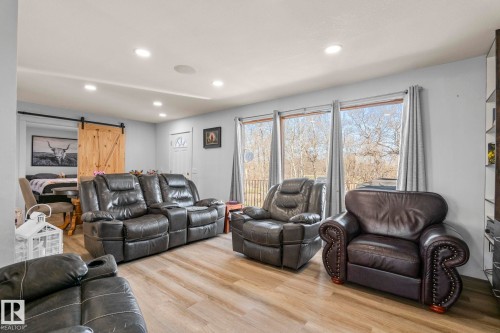 Spacious living area featuring wood-finish flooring, recessed lighting, and large windows - 23133 Twp Rd 502, Rural Leduc County, AB - Indoor Photo Showing Living Room
