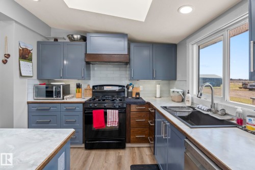 Modern kitchen featuring blue cabinetry, light wood-finish countertops, white subway tile backsplash, and stainless steel appliances - 23133 Twp Rd 502, Rural Leduc County, AB - Indoor Photo Showing Kitchen