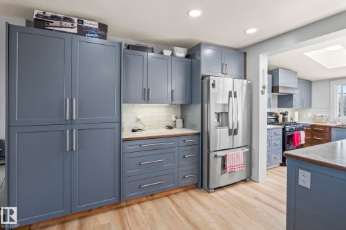 Kitchen featuring light wood-finish flooring, recessed lighting, and a white subway tile backsplash - 23133 Twp Rd 502, Rural Leduc County, AB - Indoor Photo Showing Kitchen