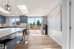 Kitchen featuring blue cabinetry with white countertops, white tile backsplash, and a central island with bar seating - 