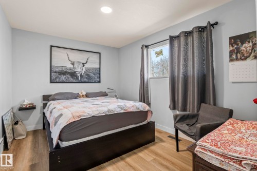 Light-filled room featuring wood-finish flooring, light blue walls, and a recessed ceiling light - 23133 Twp Rd 502, Rural Leduc County, AB - Indoor Photo Showing Bedroom