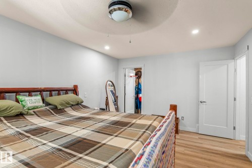 Bedroom featuring light gray walls, wood-finish flooring, recessed lighting, and a ceiling fan with integrated lighting - 23133 Twp Rd 502, Rural Leduc County, AB - Indoor Photo Showing Bedroom