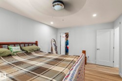 Bedroom featuring light gray walls, wood-finish flooring, recessed lighting, and a ceiling fan with integrated lighting - 