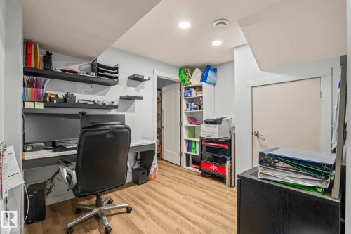 Dedicated office space featuring wood-finish flooring, recessed lighting, built-in shelving, and a built-in desk with a light-toned countertop - 23133 Twp Rd 502, Rural Leduc County, AB - Indoor Photo Showing Office