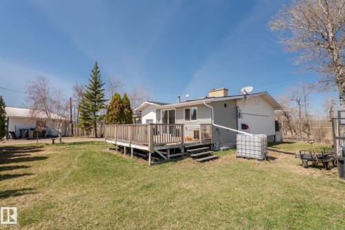 Rear exterior with a spacious wooden deck featuring a railing system and steps - 23133 Twp Rd 502, Rural Leduc County, AB - Outdoor