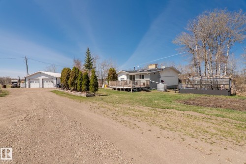 Gravel driveway leading to a two-door garage structure - 23133 Twp Rd 502, Rural Leduc County, AB - Outdoor
