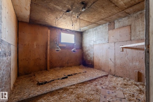 Utility space with plywood-paneled walls and a small window - 23133 Twp Rd 502, Rural Leduc County, AB - Indoor