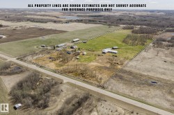 Expansive land parcel featuring multiple outbuildings, open fields, and treed areas - 