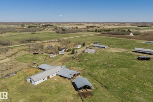 Expansive agricultural property featuring multiple outbuildings, open fields, and wooded areas - 23133 Twp Rd 502, Rural Leduc County, AB - Outdoor With View