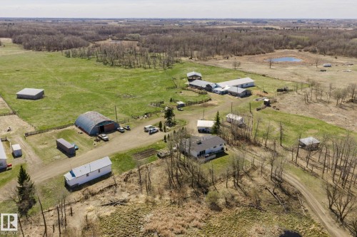 Expansive rural property featuring a primary residence, multiple outbuildings, open fields, and wooded areas - 23133 Twp Rd 502, Rural Leduc County, AB - Outdoor With View