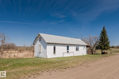 White clapboard structure with a metal roof, situated on a grassy lot - 23133 Twp Rd 502, Rural Leduc County, AB - Outdoor