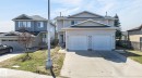 Two-story residence featuring light-colored siding and a dual-door garage with concrete driveway - 4603 126 Avenue, Edmonton, AB  - Outdoor With Facade 