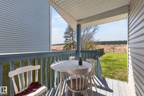 Covered porch featuring a painted wood floor and railing, white vinyl siding, and a light-colored soffit - 4603 126 Avenue, Edmonton, AB - Outdoor With Deck Patio Veranda With Exterior