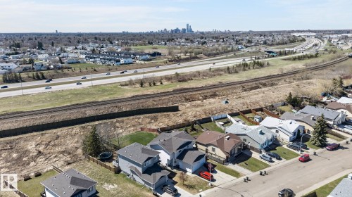 Aerial perspective showcasing residential properties near a multi-lane highway and railroad tracks - 4603 126 Avenue, Edmonton, AB - Outdoor With View