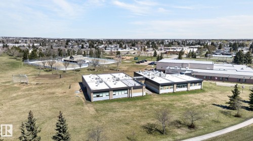 Expansive green space featuring a large sports field, nearby athletic courts, and a community building - 4603 126 Avenue, Edmonton, AB - Outdoor With View