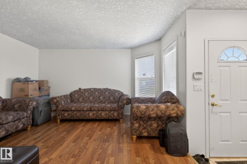 Living area featuring wood-finish flooring, white walls, and a textured white ceiling - 4603 126 Avenue, Edmonton, AB - Indoor Photo Showing Living Room