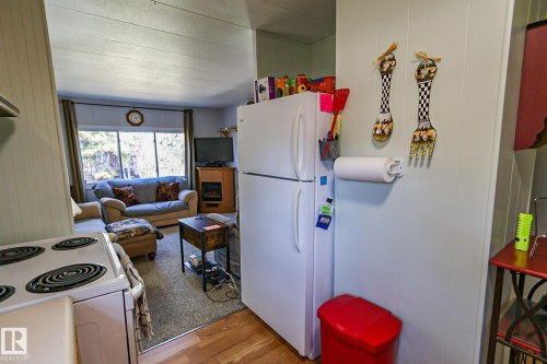 White top-freezer refrigerator with light wood-finish flooring - 331 60417 Range Road 124, Rural St. Paul County, AB 