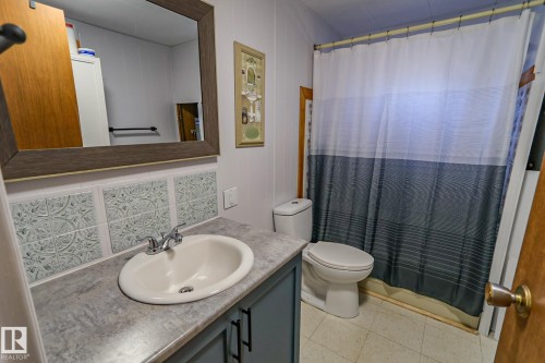 Bathroom featuring a vanity with a drop-in sink, gray countertop, and built-in cabinetry - 331 60417 Range Road 124, Rural St. Paul County, AB 