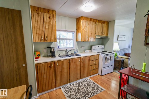 Kitchen featuring wood-finish cabinetry and matching wood-finish flooring - 331 60417 Range Road 124, Rural St. Paul County, AB 