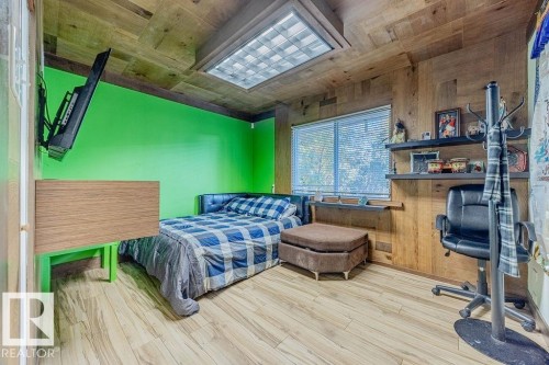 Spacious outdoor deck featuring wood-finish flooring, dark wood railings with black metal balusters, and a built-in lattice privacy screen - 12339 89 Street, Edmonton, AB - Outdoor With Deck Patio Veranda With Exterior