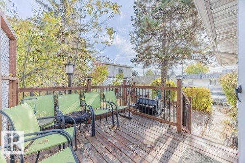 Expansive outdoor deck featuring wood-finish flooring and a partial railing with black balusters - 12339 89 Street, Edmonton, AB - Outdoor With Deck Patio Veranda