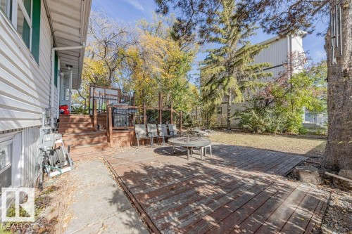 Spacious backyard featuring a sloped lawn, mature trees, and a multi-level wooden deck - 12339 89 Street, Edmonton, AB - Outdoor