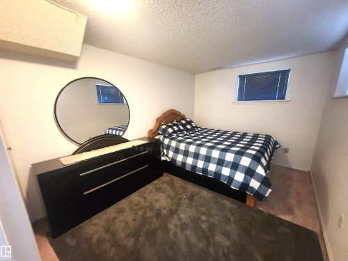 White walls with a textured ceiling and baseboard trim - 12339 89 Street, Edmonton, AB - Indoor Photo Showing Bedroom