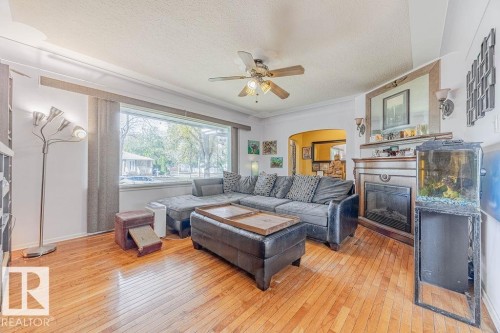 Living space featuring wood-finish flooring, a decorative ceiling fan, and arched doorways - 12339 89 Street, Edmonton, AB - Indoor Photo Showing Living Room
