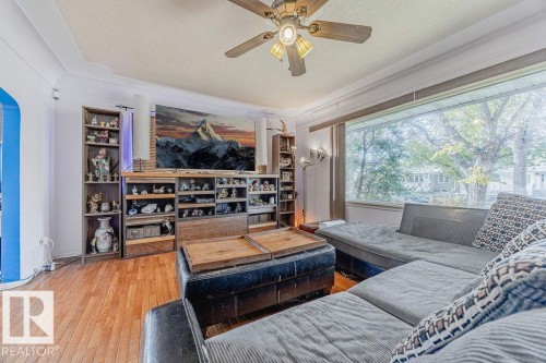 Hardwood flooring extends throughout this space, featuring large windows and a pass-through opening to an additional room - 12339 89 Street, Edmonton, AB -  With Deck Patio Veranda