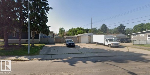 Property featuring a paved driveway, mature trees, and a detached garage with two garage doors - 11834 44 Street, Edmonton, AB - Outdoor