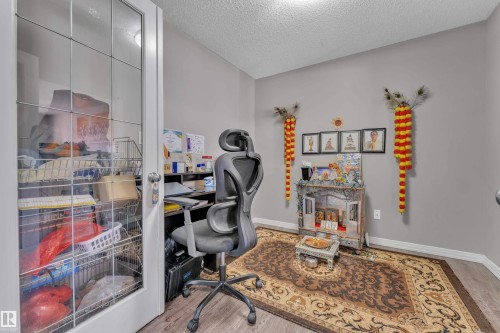 Room featuring a glass-paneled door, wood-finish flooring, and light gray walls - 5520 5 Avenue, Edmonton, AB - Indoor Photo Showing Office