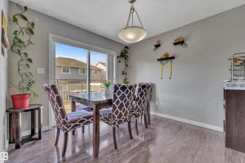 Dining area featuring sliding glass doors to the exterior deck, wood-finish flooring, and a semi-flush ceiling light fixture - 5520 5 Avenue, Edmonton, AB - Indoor Photo Showing Dining Room