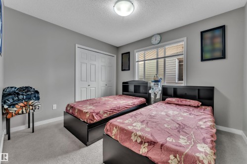Recessed lighting illuminates the carpeted room featuring a large window, a double-door closet, and neutral wall tones - 5520 5 Avenue, Edmonton, AB - Indoor Photo Showing Bedroom