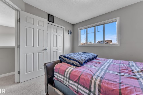 Bedroom featuring a large window, light gray painted walls, and light-toned carpet flooring - 5520 5 Avenue, Edmonton, AB - Indoor Photo Showing Bedroom