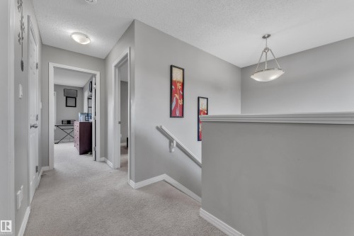 Upper-level hallway featuring light gray walls, plush carpet flooring, white trim, and flush-mount lighting - 5520 5 Avenue, Edmonton, AB - Indoor Photo Showing Other Room