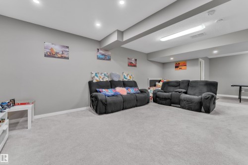 Carpeted recreation room featuring recessed lighting and a drop ceiling with integrated fluorescent lighting - 5520 5 Avenue, Edmonton, AB - Indoor Photo Showing Basement