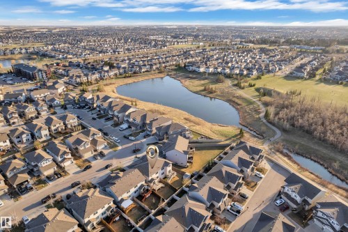 Aerial perspective highlighting the property within a residential development, featuring a nearby pond and green space - 5520 5 Avenue, Edmonton, AB - Outdoor With View