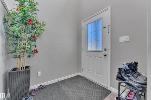 Entryway featuring a paneled door with frosted glass inserts, gray wall paint, and wood-finish flooring - 5520 5 Avenue, Edmonton, AB - Indoor Photo Showing Other Room