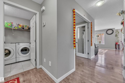 Dedicated laundry area with tiled flooring, wire shelving, and overhead lighting - 5520 5 Avenue, Edmonton, AB - Indoor Photo Showing Laundry Room