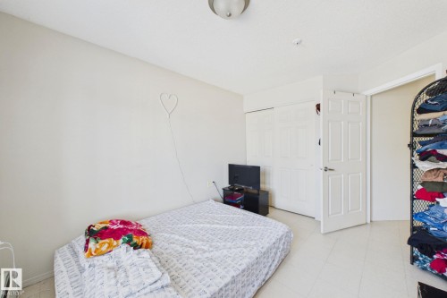 Bedroom featuring light neutral wall paint, white trim, and a flush mount ceiling light - 220 80A Kelloway Crescent, Red Deer, AB - Indoor Photo Showing Bedroom